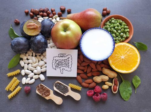 High fiber foods for healthy bowel. Healthy foods for intestine health. Diet and nutrition for constipation. Assortment of foods for healthy gut and digestive system with intestine anatomical drawing.